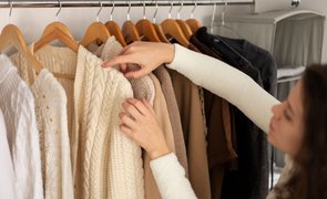 mulher pegando roupas penduradas