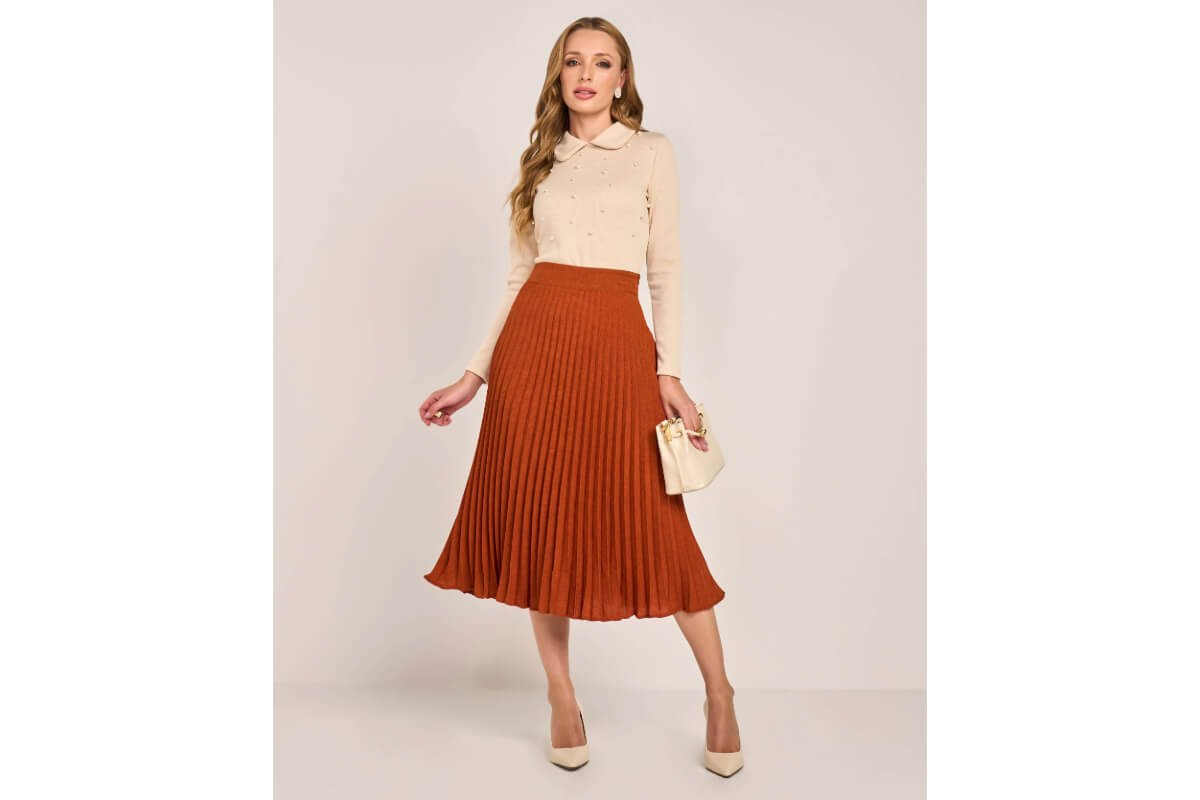 mulher usando saia plissada midi mais um sueter