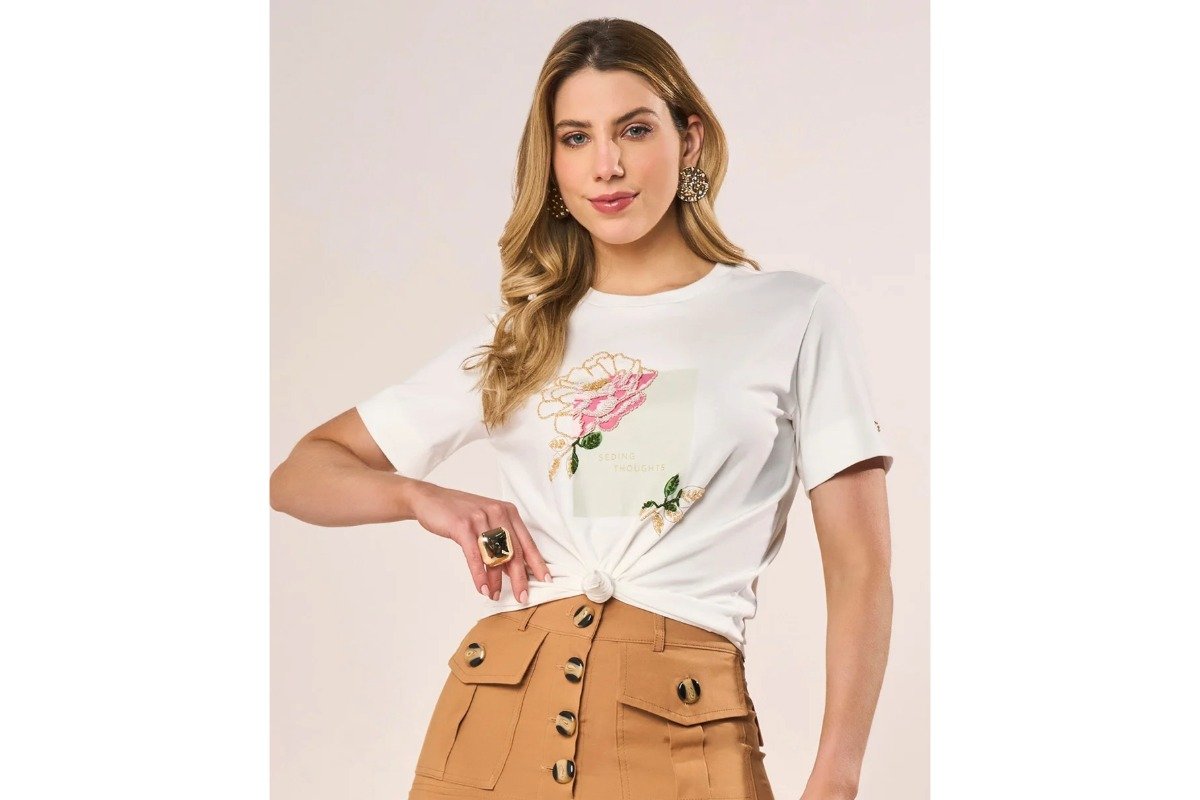 mulher usanda camiseta branca com estampa floral e saia