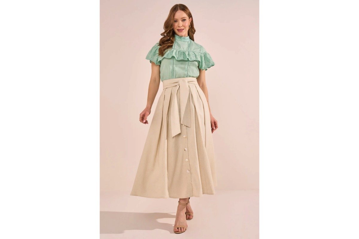 mulher usando saia midi bege e blusa verde