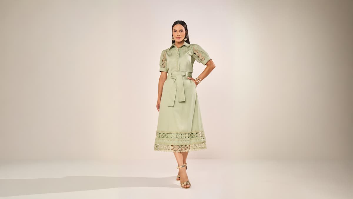 mulher com cabelos escuros usando vestido verde com cinto