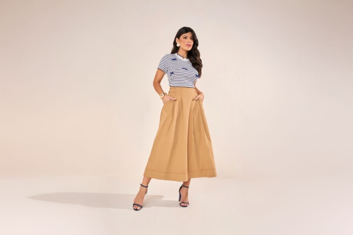 modelo usando saia midi bege e blusa listrada