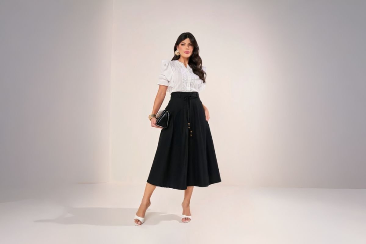 modelo usando saia midi preta e blusa branca